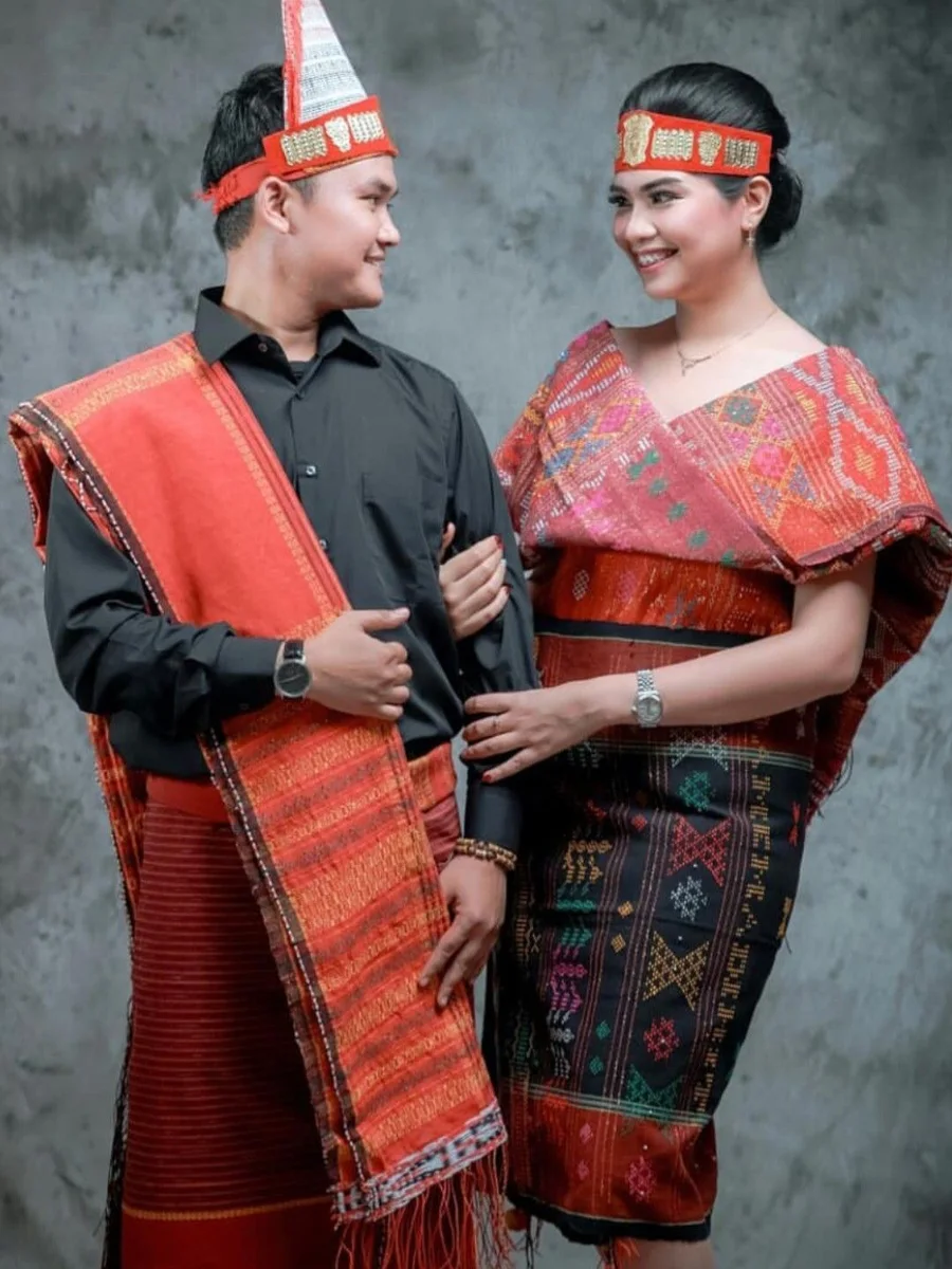 Pasangan pengantin mengenakan set adat Batak