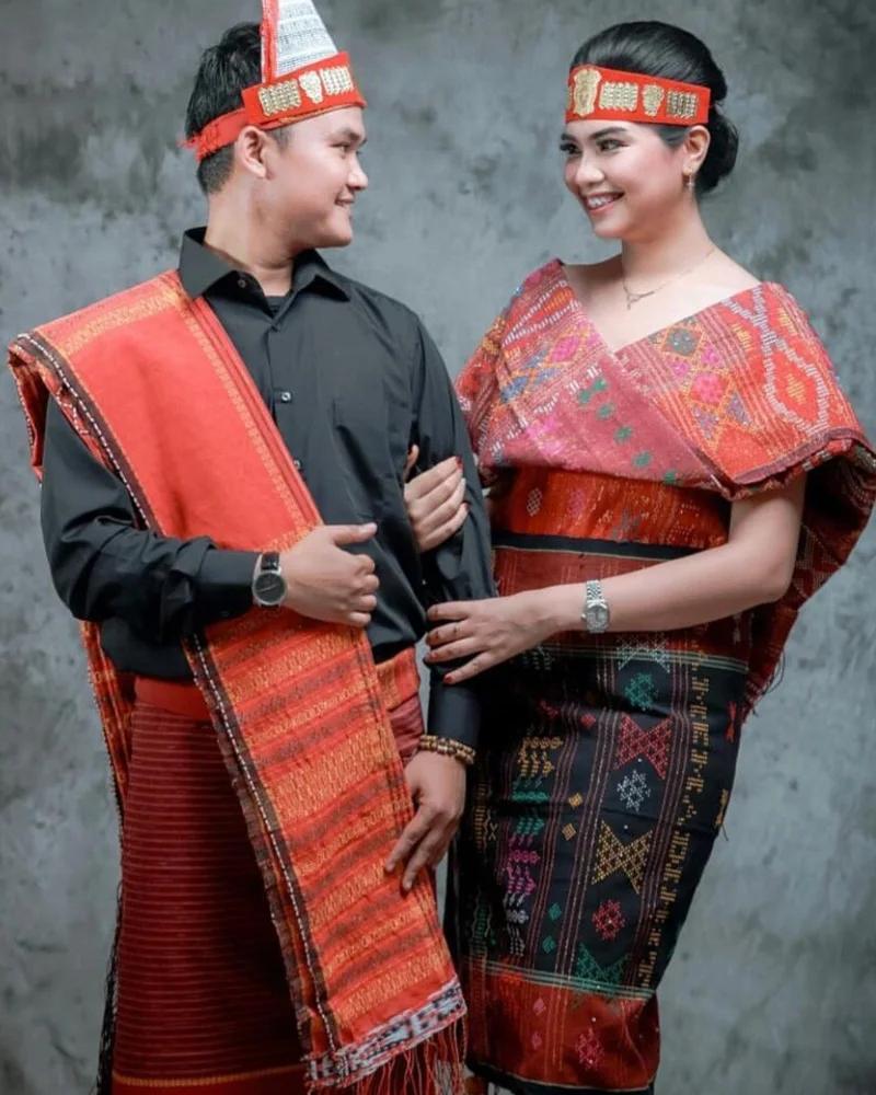 Pasangan pengantin mengenakan set adat Batak berulos